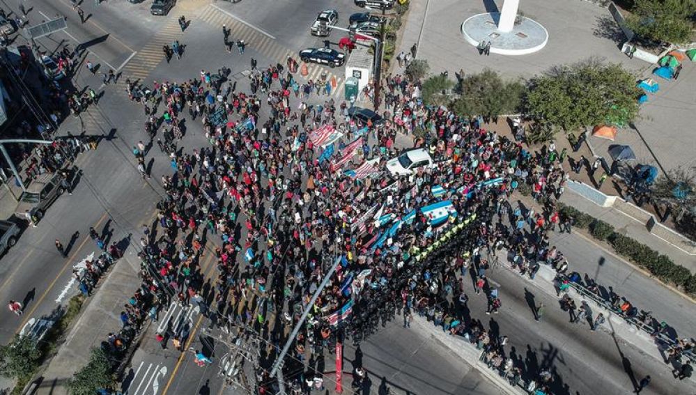 Un grupo de migrantes tratan de cruzar la garita El Chaparral, en Tijuana (México)