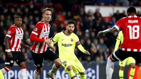 Leo Messi defiende un bal&oacute;n ante los jugadores del PSV