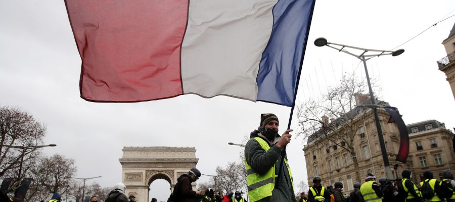 Un manifestante de los chalecos amarillos ondea una bandera tricolora francesa durante una manifestación en París Un manifestante de los chalecos amarillos ondea una bandera tricolora francesa durante una manifestación en París