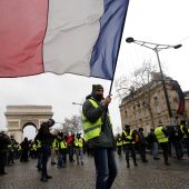 Un manifestante de los chalecos amarillos ondea una bandera tricolora francesa durante una manifestación en París
