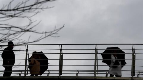 Imagen de archivo: varias personas se protegen del agua y del viento.
