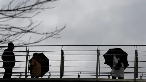 Imagen de archivo: varias personas se protegen del agua y del viento. Imagen de archivo: varias personas se protegen del agua y del viento.
