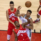 Giannis Antetokounmpo y Serge Ibaka pelean por un balón Giannis Antetokounmpo y Serge Ibaka pelean por un balón