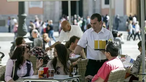Un camarero atiende la mesa de una terraza. empleo hosteleria_643x397