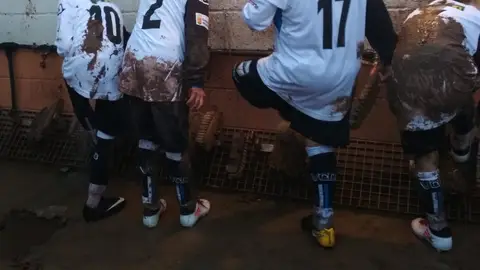 Niños limpiándose el barro tras un partido de fútbol Niños limpiándose el barro tras un partido de fútbol