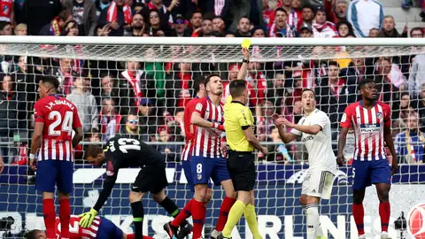 Estrada Fernández muestra una tarjeta amarilla durante el Atlético-Real Madrid Estrada Fernández muestra una tarjeta amarilla durante el Atlético-Real Madrid