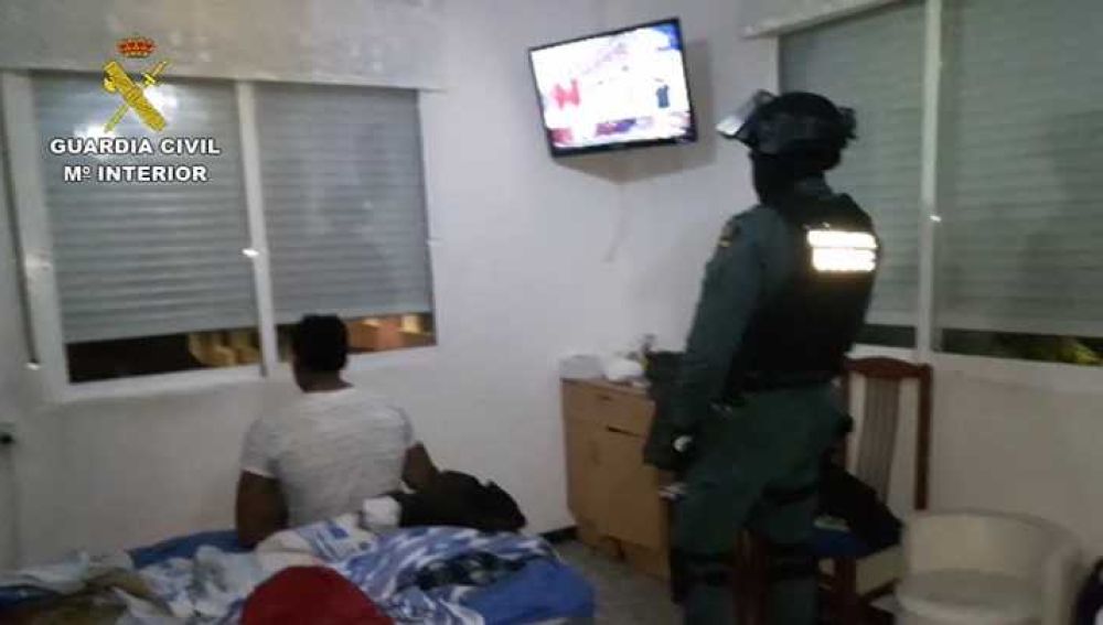 Un agente de la Guardia Civil de Alicante junto a uno de los detenidos