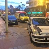 Vehículo de la Policía Nacional y ambulancia junto al edificio de la vivienda asaltada
