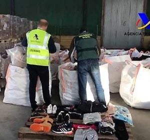Agentes de la Guardia Civil junto a productos falsificados intervenidos en Elche Agentes de la Guardia Civil junto a productos falsificados intervenidos en Elche