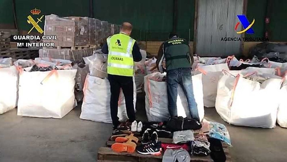 Agentes de la Guardia Civil junto a productos falsificados intervenidos en Elche 