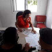 Una trabajadora de Cruz Roja ayudando a cumplimentar un bono social