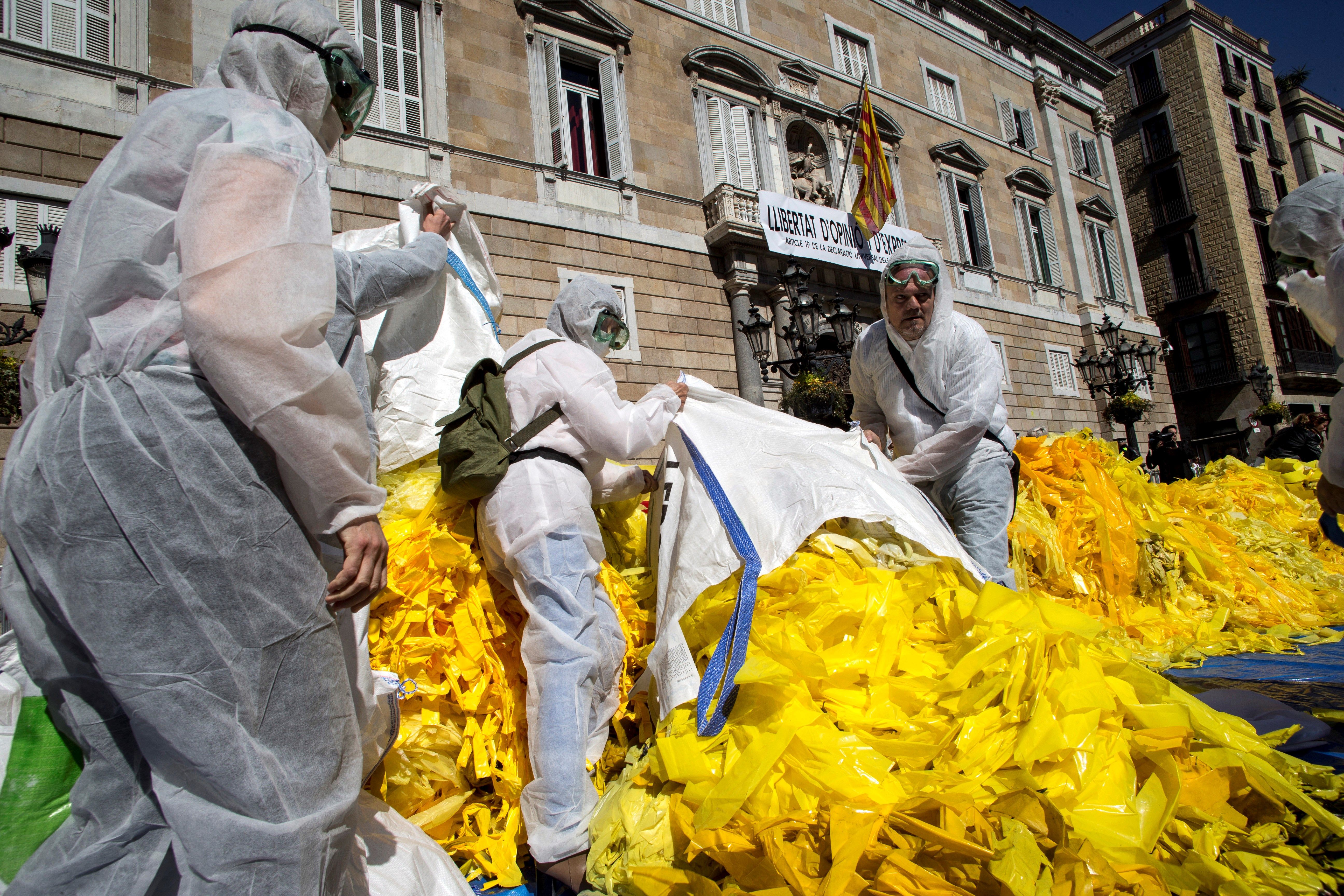 Activistas antiindependentistas vuelcan sacos de lazos amarillos frente a la Generalitat Activistas antiindependentistas vuelcan sacos de lazos amarillos frente a la Generalitat