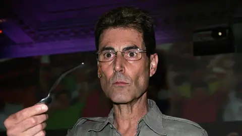 El ilusionista Uri Geller doblando una cuchara El ilusionista Uri Geller doblando una cuchara