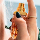 Una mujer echándose perfume
