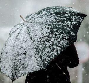 Imagen de archivo de una persona con un paraguas mientras nieva Imagen de archivo de una persona con un paraguas mientras nieva