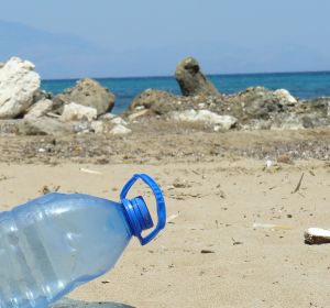 Una botella de plástico junto con otros residuos en una playa Una botella de plástico junto con otros residuos en una playa