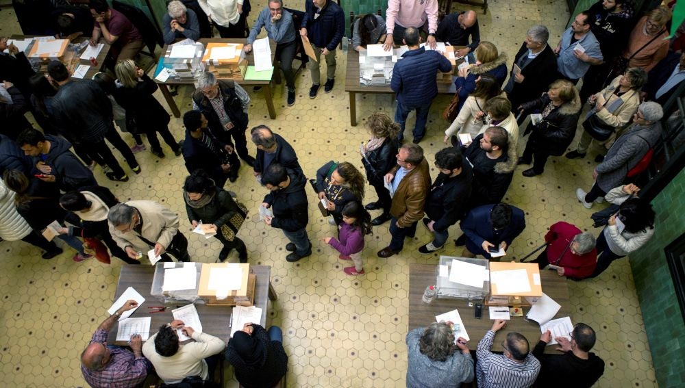 Personas votando en un colegio electoral
