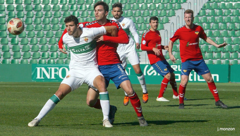 Nacho Ramón pugna por un balón ante la defensa férrea de un rival.