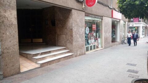 Establecimiento objeto de robo y portal del edificio desde cuyo interior se ha realizado el agujero. 