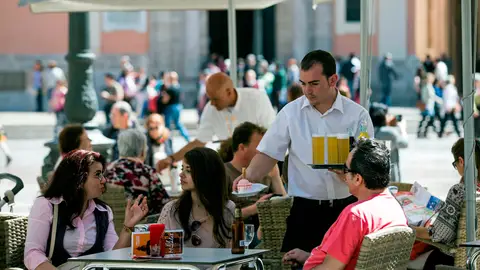 Un camarero sirviendo en una terraza Un camarero sirviendo en una terraza