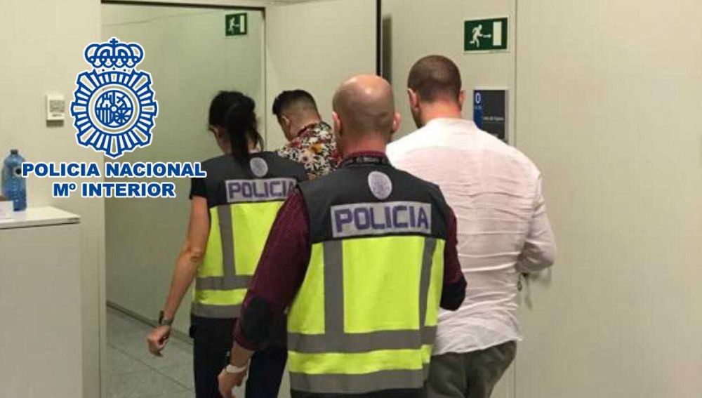 Agentes de la Policía Nacional con los detenidos en el Aeropuerto Alicante-Elche.