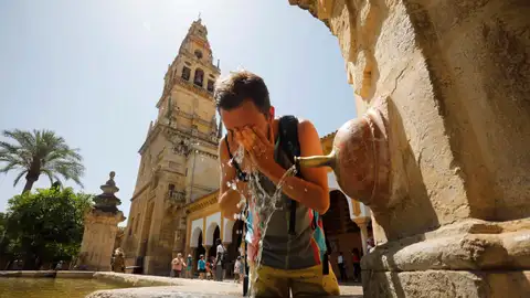 Un turista se refresca en el patio de los Naranjos de la Mezquita-Catedral de Córdoba Un turista se refresca en el patio de los Naranjos de la Mezquita-Catedral de Córdoba