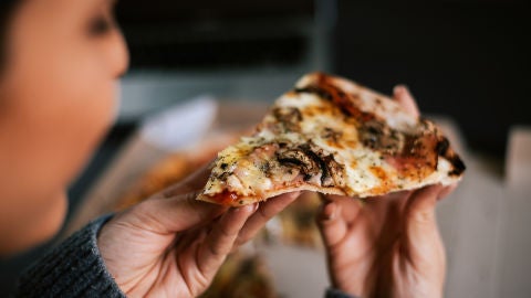 Joven comiendo pizza