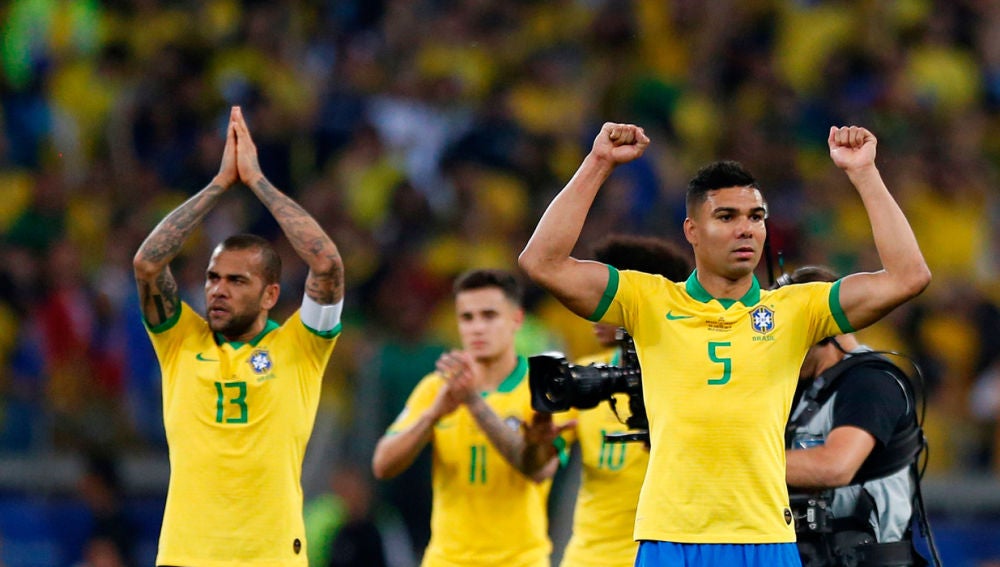 Dani Alves y Casimiro de Brasil celebran al final del partido Brasil-Argentina.