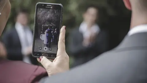 Invitada a una boda haciendo fotos Invitada a una boda haciendo fotos