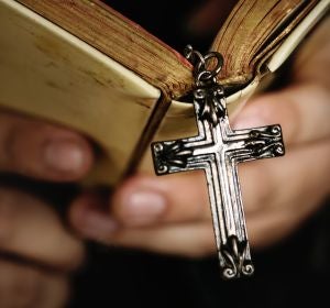Una cruz colgando de una Biblia Una cruz colgando de una Biblia