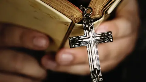 Una cruz colgando de una Biblia Una cruz colgando de una Biblia