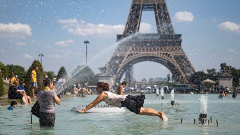 Un grupo de personas se ba&ntilde;a en las fuentes del Trocadero de Par&iacute;s en plena ola de calor