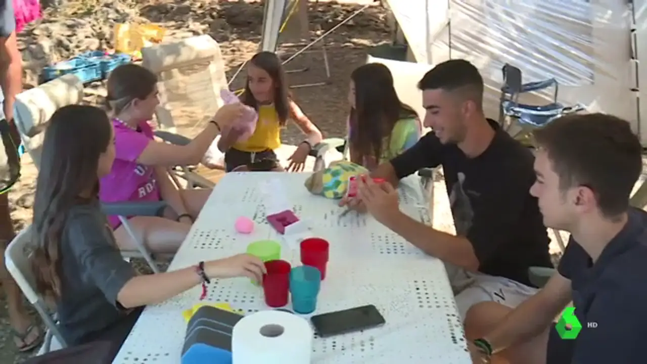Un grupo de jóvenes jugando en la mesa de un camping Un grupo de jóvenes jugando en la mesa de un camping
