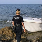 Una agente de la Policía Local de Elche junto a la embarcación con migrantes que ha llegado a la playa del Carabassí. Una agente de la Policía Local de Elche junto a la embarcación con migrantes que ha llegado a la playa del Carabassí.