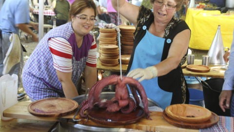 Una pulpeira muestra uno de los pulpos cocidos durante la Festa do Pulpo de O Carballi&ntilde;o