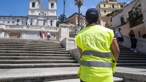 Un policía vigila que los turistas no se sienten en las escaleras de la Plaza de España en Roma Un policía vigila que los turistas no se sienten en las escaleras de la Plaza de España en Roma