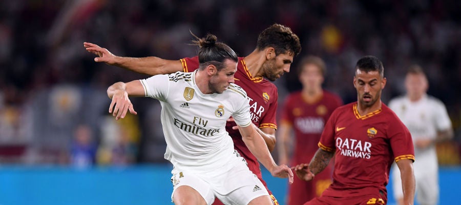 Bale lucha por la posesión del balón con los jugadores de la Roma Bale lucha por la posesión del balón con los jugadores de la Roma