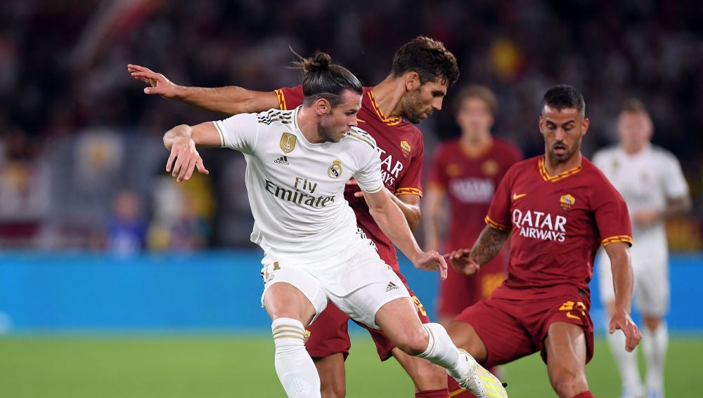 Bale lucha por la posesión del balón con los jugadores de la Roma