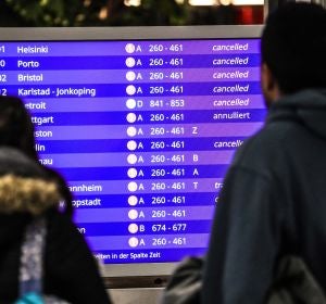 Pasajeros miran los vuelos cancelados en una pantalla informativa Pasajeros miran los vuelos cancelados en una pantalla informativa