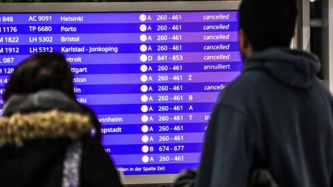 Pasajeros miran los vuelos cancelados en una pantalla informativa Pasajeros miran los vuelos cancelados en una pantalla informativa