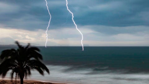 Dos rayos caen en el mar en Arenales del Sol de Elche.