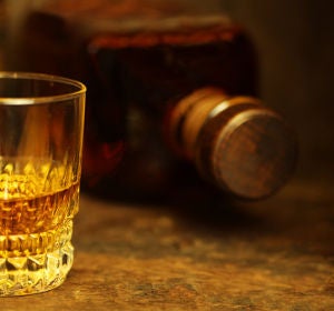 Imagen de archivo de una botella y un vaso de alcohol Imagen de archivo de una botella y un vaso de alcohol