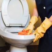 Una persona limpiando un váter
