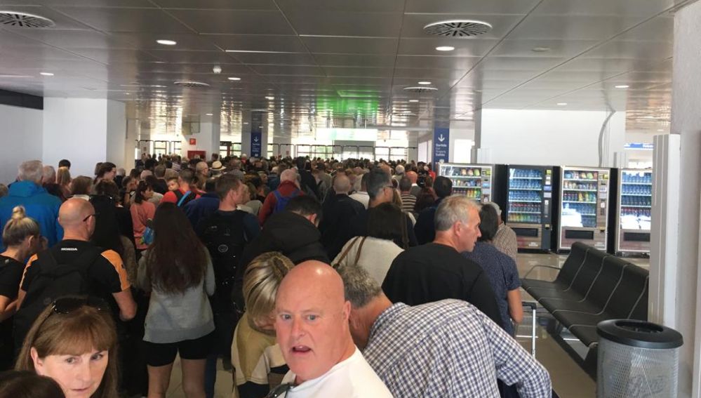 Pasajeros esperando para pasar los controles en el Aeropuerto de Palma. 