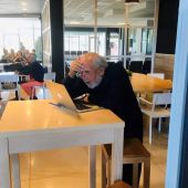 Michel Mayor en el aeropuerto de San Sebastián leyendo sus mensajes. | @NobelPrize