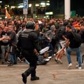 Un mosso d'esquadra durante una de las cargas contra las miles de personas se agolpan ante el Aeropuerto del Prat después de que la plataforma Tsunami Democràtic haya llamado a paralizar la actividad del aeropuerto, en protesta por la condena a los líderes del 'procés'.