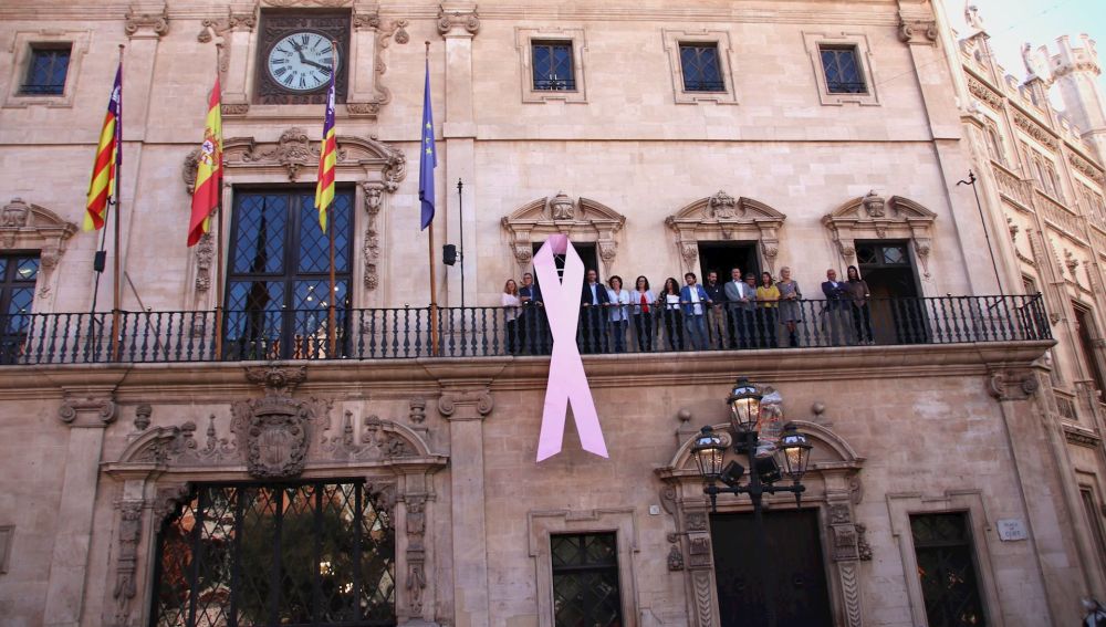 Una gran lazo rosa cuelga de la fachada del Ayuntamiento de Palma, con motivo del Día Mundial contra el cáncer de mama 
