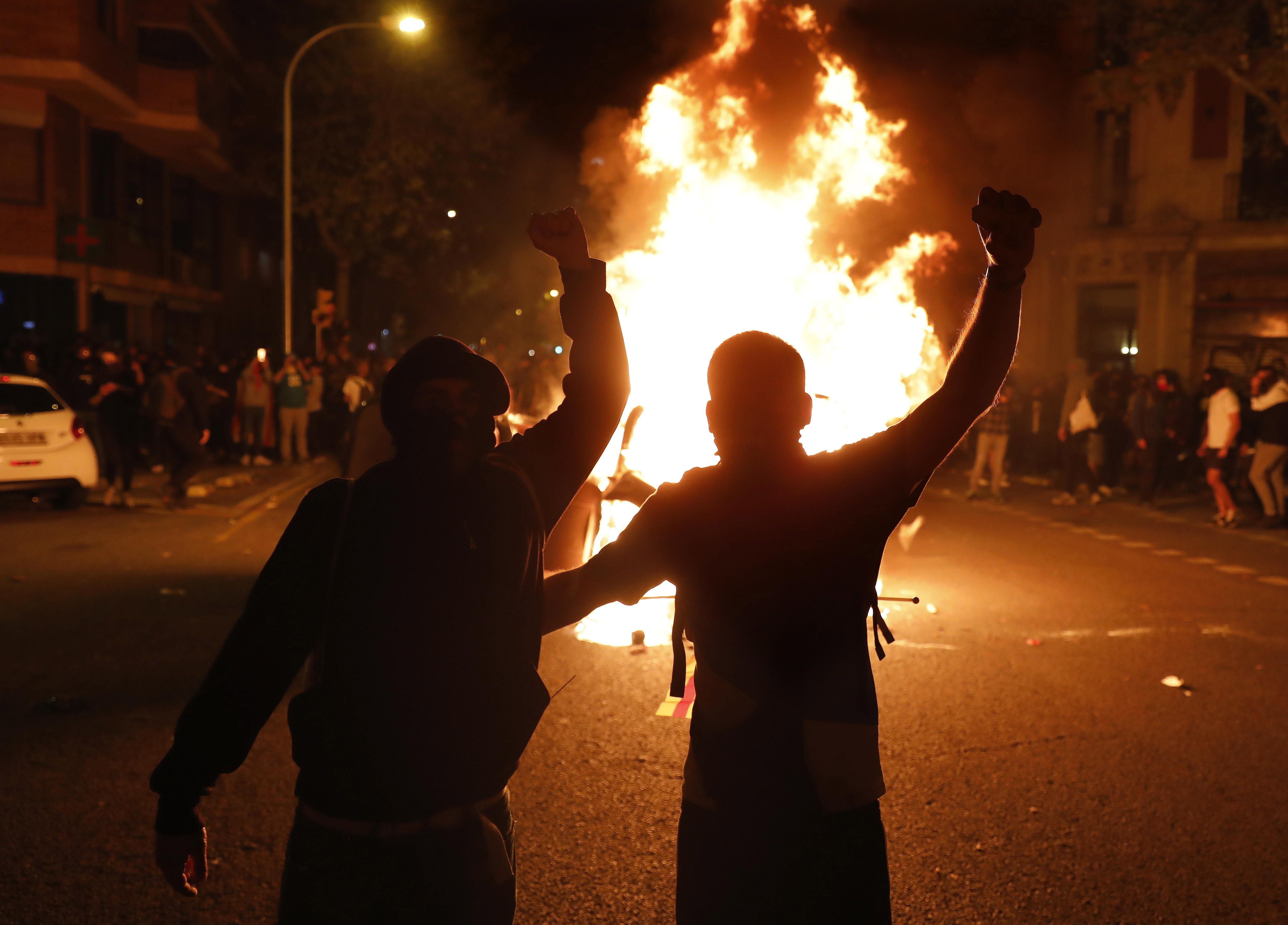 Las imágenes de un repartidor trabajando o de unas chicas de copas al lado de los disturbios en Cataluña se vuelven virales Las imágenes de un repartidor trabajando o de unas chicas de copas al lado de los disturbios en Cataluña se vuelven virales