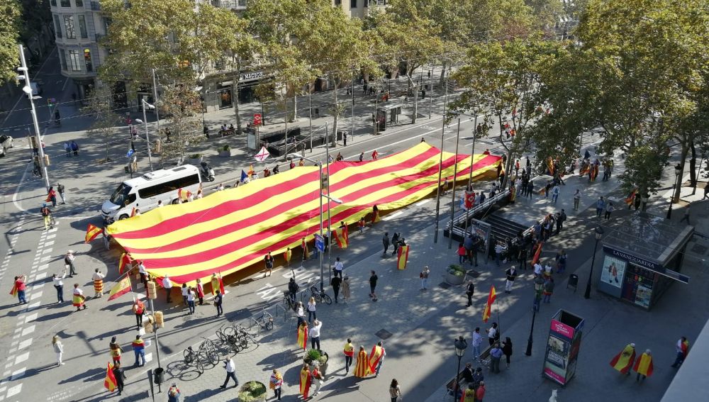 Varias personas portan una gigantesca senyera antes de que comience la manifestación constitucionalista Varias personas portan una gigantesca senyera antes de que comience la manifestación constitucionalista