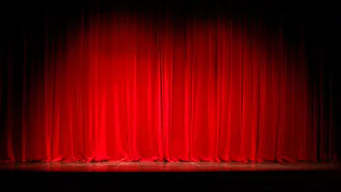 Escenario en el que está a punto de abrirse el telón. Escenario en el que está a punto de abrirse el telón.